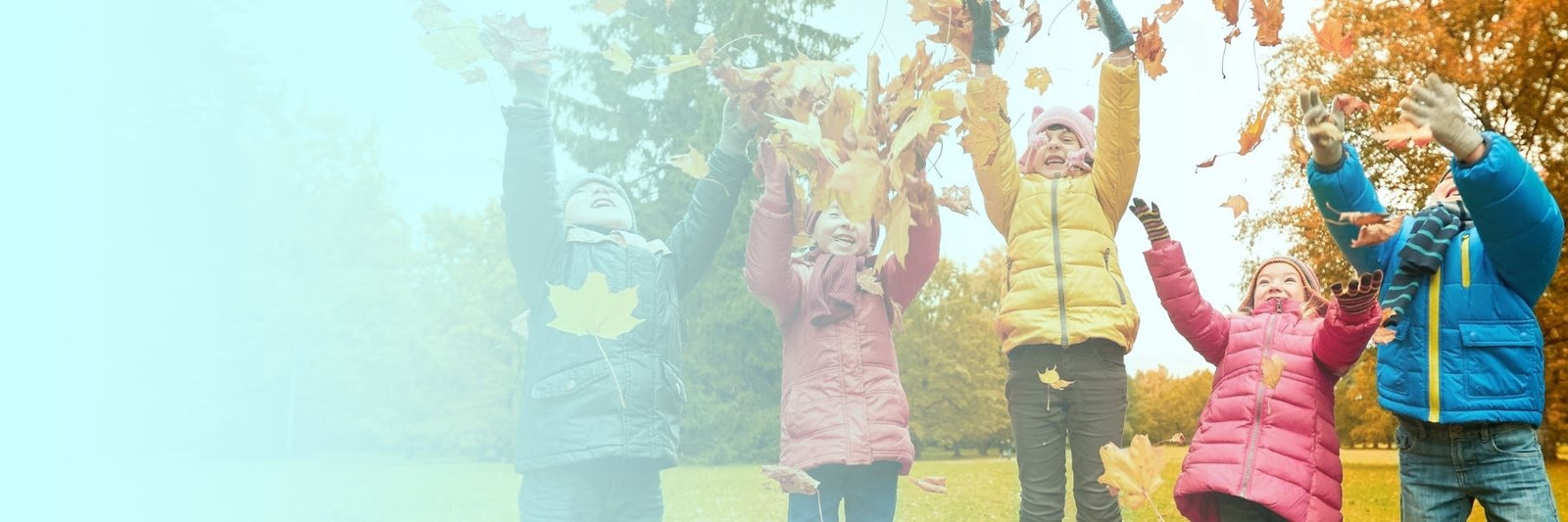 Small children laughing and throwing autumn leaves in the air - Cranberry Eco Preschool