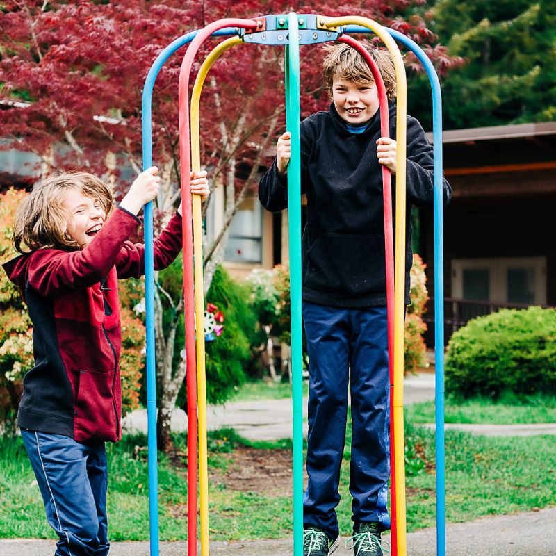 Two young boys playing on the merry-go-round