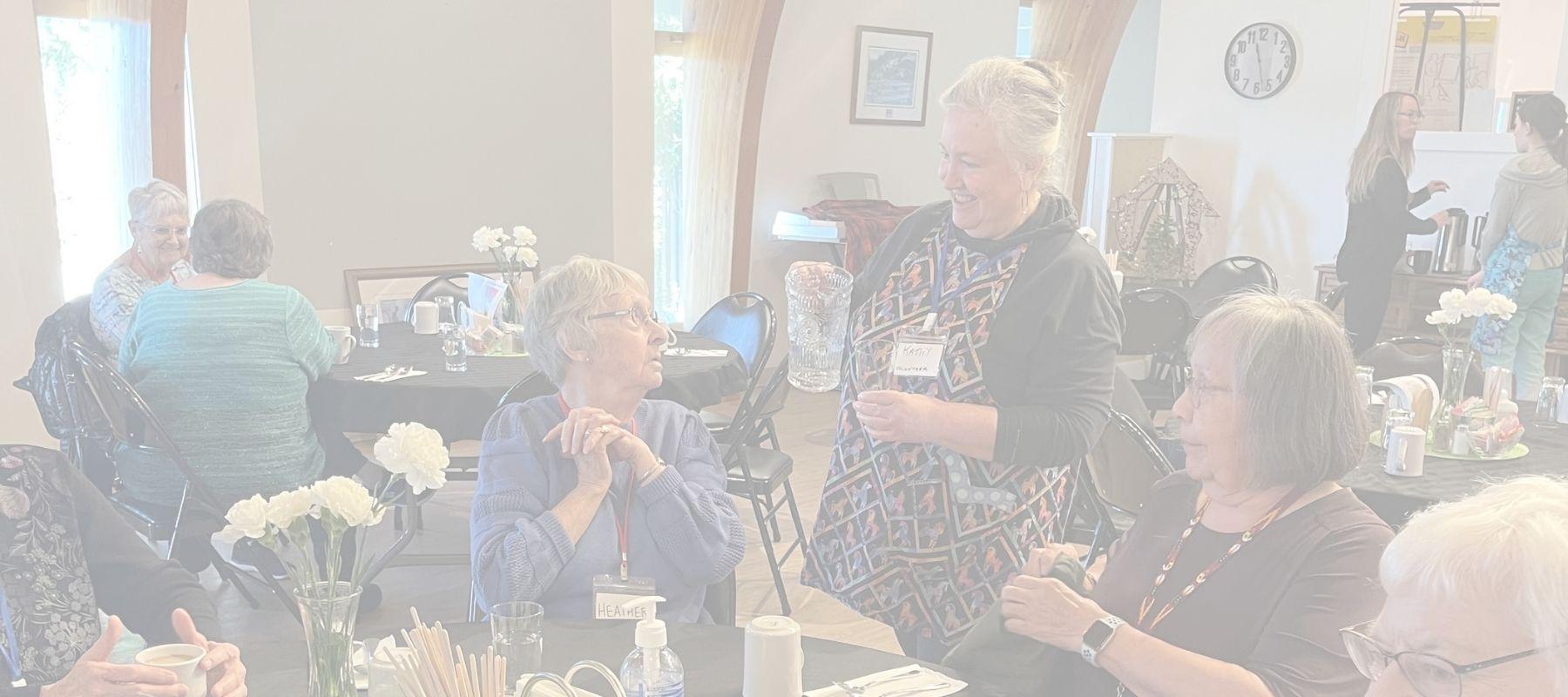 A volunteer pouring a glass of water for a senior at the Gerry Gray Place