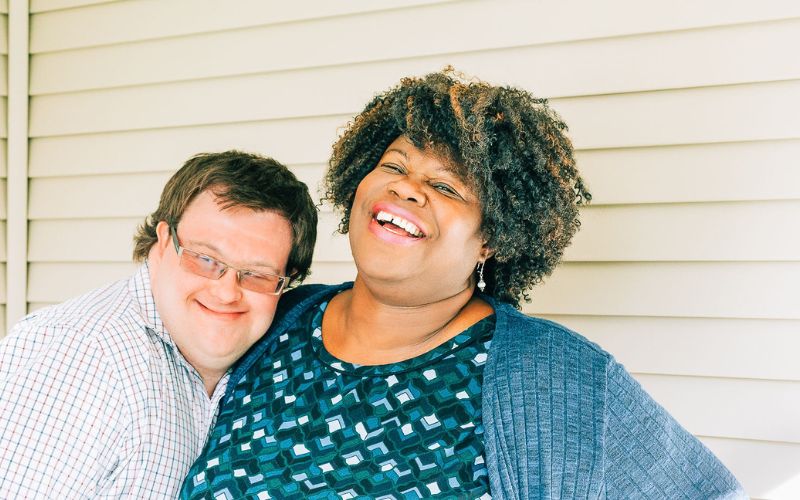 Image of a HomeShare Provider and a young man with Down Syndrome embracing and laughing