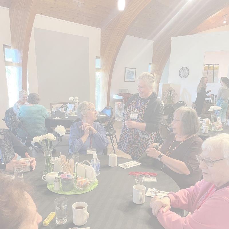 A volunteer pouring a glass of water for a senior at the Gerry Gray Place