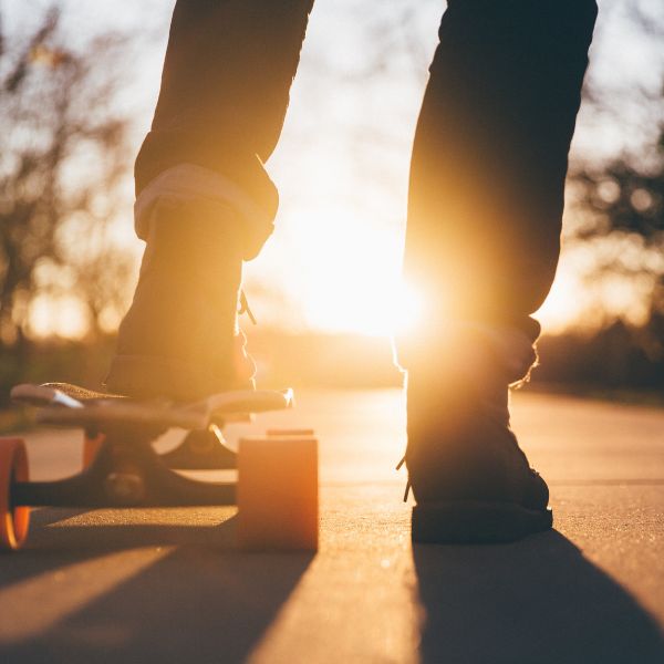 Someone on a skateboard with the sun setting in the background